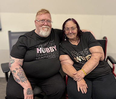 Man and woman with arms around each other sitting on bench