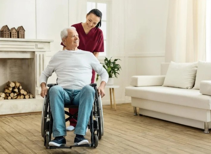 Woman pushing elderly man in wheelchair