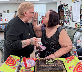 older newlywed couple feeding cake to each other