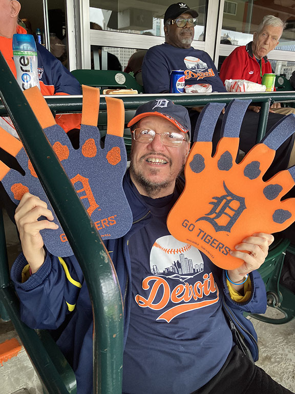 elderly man at Detroit Tigers game holding foam signs